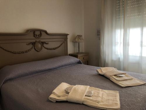 a bed with a blanket on top of it at City Garden Guest House in Olbia