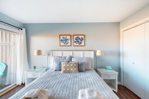 een slaapkamer met een bed met blauwe muren en 2 tafels bij Great Lakes 5 in Glen Arbor