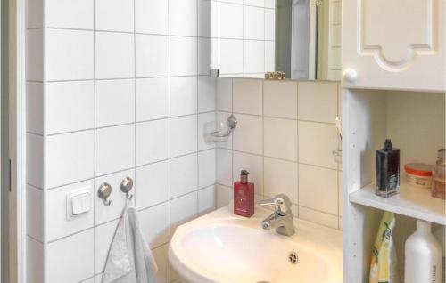 a white bathroom with a sink and a mirror at 3 Bedroom Lovely Home In Adelsö in Adelsö