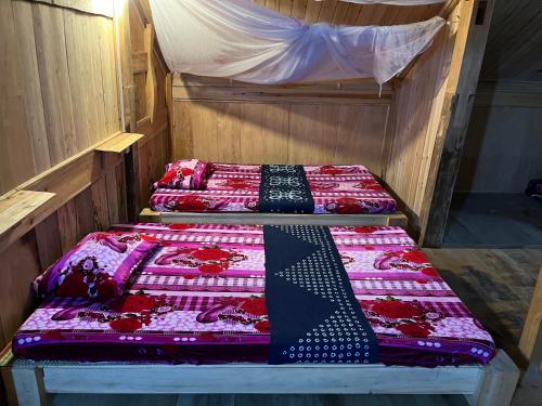 two beds with ties on them in a room at SaPa Big Tree Hmong Homestay in Sa Pa