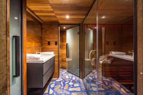 a bathroom with a shower and a sink and a tub at Maison Blanc Lodge in Auckland