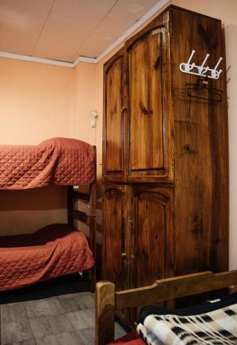 a room with a wooden cabinet and two bunk beds at Hostal Namaste in Salta