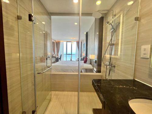 a bathroom with a shower and a sink and a bed at SeaHaven Panorama Nha Trang Superview Apartments in Nha Trang