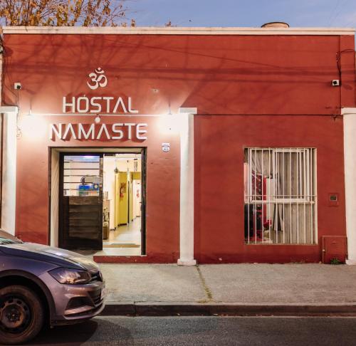 a red building with a hostel name on it at Hostal Namaste in Salta
