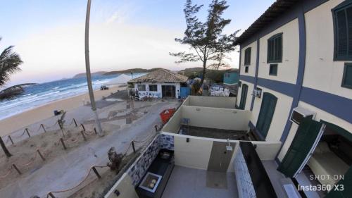 an aerial view of a beach and a building at Flat frente mar na Praia do Pero com piscina in Cabo Frio