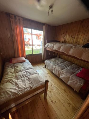 a bedroom with two bunk beds and a window at Cabañas y condominio los pretiles in Pinto