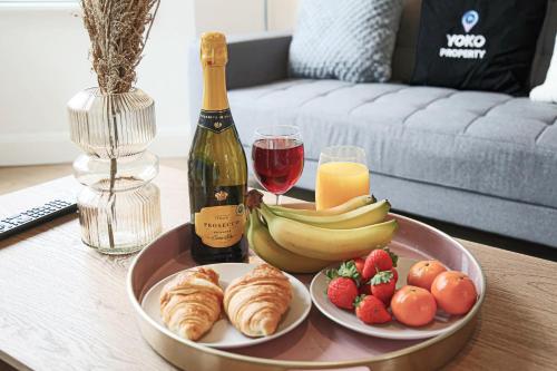 uma mesa com um prato de frutas e uma garrafa de vinho em Central House with Free Parking, Garden, Super-Fast Wifi and Smart TVs by Yoko Property em Northampton