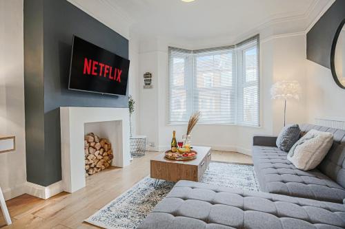 ein Wohnzimmer mit einem Sofa und einem Kamin in der Unterkunft Central House with Free Parking, Garden, Super-Fast Wifi and Smart TVs by Yoko Property in Northampton
