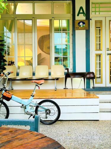 un vélo garé sur un banc devant un bâtiment dans l'établissement 小逗民宿, à Taïtung