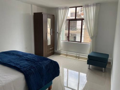 - une chambre avec un lit, une chaise et une fenêtre dans l'établissement Exclusivo Apartamento en el Centro Histórico Trujillo - 3er Piso, à Trujillo