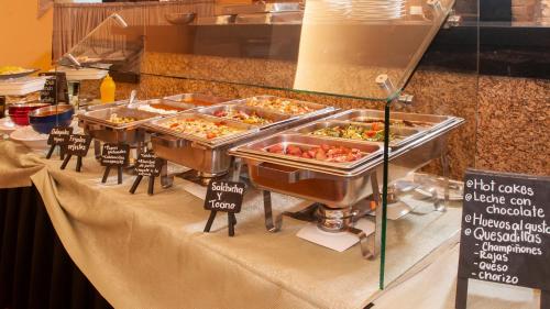 una línea de buffet con bandejas de comida en una mesa en BelAir Unique a Wyndham Hotel, en Ciudad de México