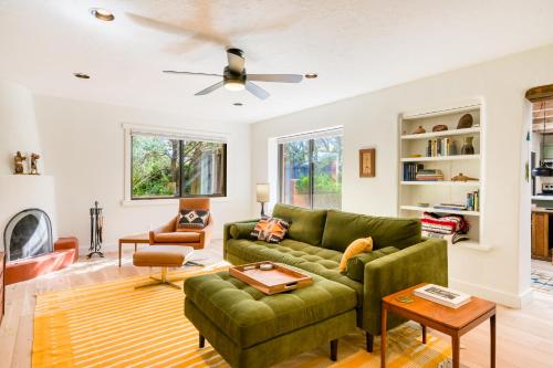 a living room with a green couch and a ceiling fan at Casita Colibri in Santa Fe