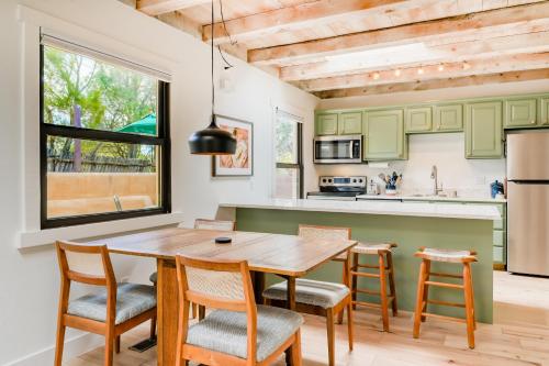 a kitchen with green cabinets and a wooden table and chairs at Casita Colibri in Santa Fe