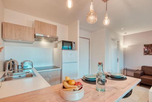 une cuisine avec une table avec un bol de fruits dessus dans l'établissement Le 102 -T2 climatisé 20 min à pied Gare St-Charles, à Marseille