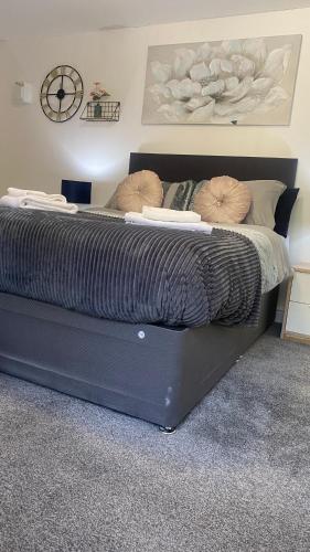 a black bed with two pillows on it in a bedroom at Hayy Studios Comfortable Stays in Deighton in Huddersfield