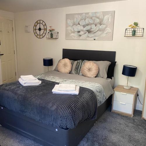 a bedroom with a bed with two night stands and two lamps at Hayy Studios Comfortable Stays in Deighton in Huddersfield