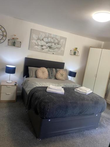 a bedroom with a bed with two towels on it at Hayy Studios Comfortable Stays in Deighton in Huddersfield