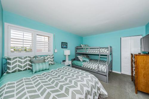a bedroom with two bunk beds and a window at La Puerta Island Retreat with Florida Flair in St Petersburg