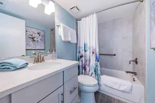 a bathroom with a sink and a toilet and a shower at La Puerta Island Retreat with Florida Flair in St Petersburg
