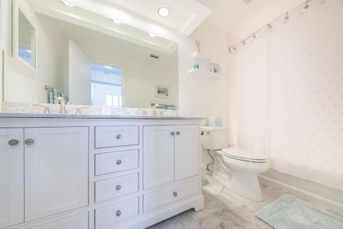 a white bathroom with a sink and a toilet at Vista Verde E Beautifully Updated, Contemporary Condo in St Petersburg