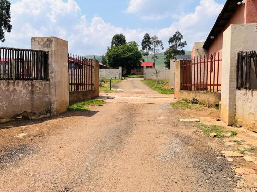 an empty dirt road next to a fence at Izinjiki Namacusi Guest House in Amsterdam