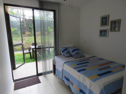 a bedroom with a bed and a sliding glass door at La Tebaida Quindío Reserva de la Colina E104 in La Tebaida