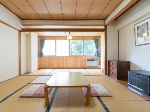 a living room with a table and a window at Villa Alpen in Yamanouchi