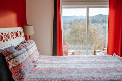 ein Schlafzimmer mit einem Bett und einem großen Fenster in der Unterkunft Pleasant Grove Cottages - Misty Mtn (#113) / Lazy Bear (#115) in Weaverville