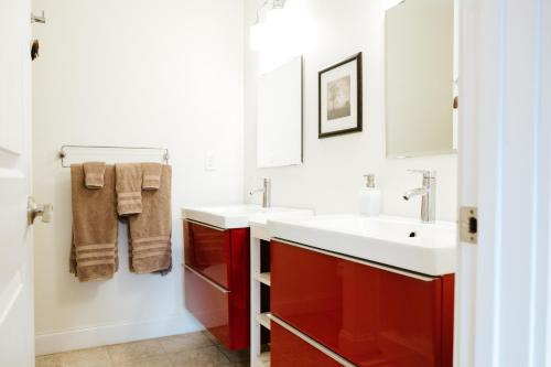 ein Badezimmer mit roten Schränken und einem weißen Waschbecken in der Unterkunft Pleasant Grove Cottages - Misty Mtn (#113) / Lazy Bear (#115) in Weaverville