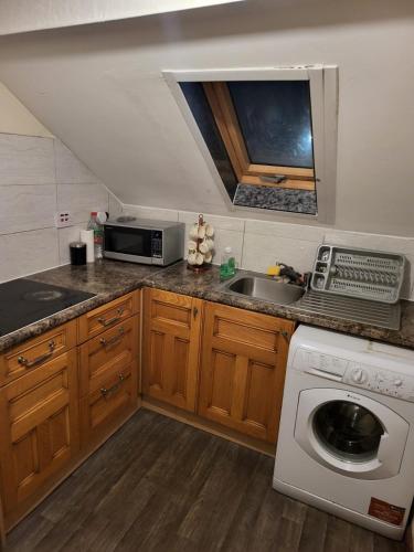 a kitchen with a sink and a washing machine at Unique private rooms (1) in Bolton