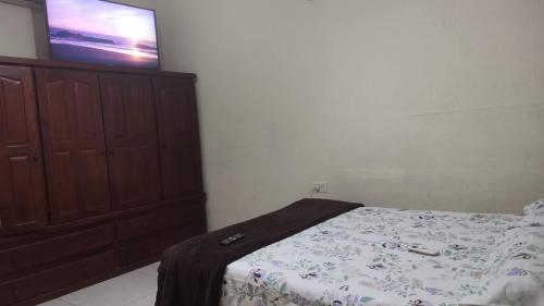 1 dormitorio con 1 cama y TV en la pared en Residencia Dos Soles -Resistencia Chaco en Resistencia