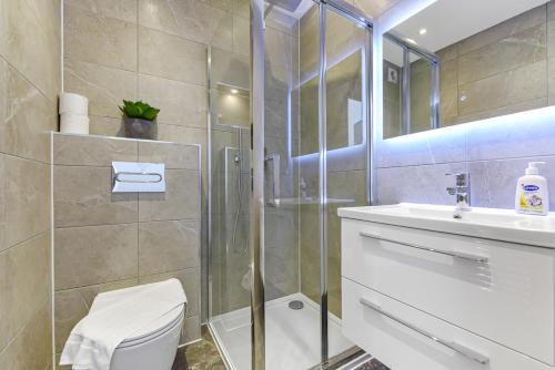 倫敦的住宿－Lovely 2 Bedroom Apartment in Greater London，带淋浴、卫生间和盥洗盆的浴室