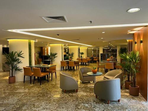 a hotel lobby with tables and chairs and a restaurant at Oasis Imperial & Fortaleza in Fortaleza