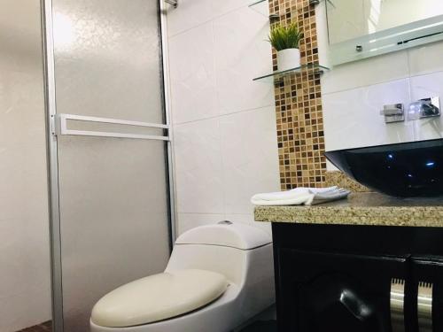 a bathroom with a toilet and a glass shower at Aloja-T en zona centrica de Armenia in Armenia