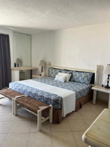 Un dormitorio con una cama grande y un banco en Hermoso Depto con vista al mar en zona hotelera., en Cancún