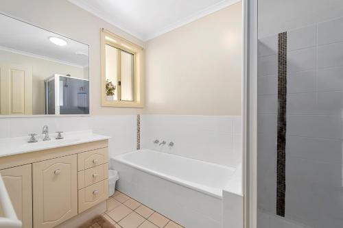 a white bathroom with a tub and a sink and a shower at H1111 Mission Terrace Lakewood Heights Estate in Laurieton