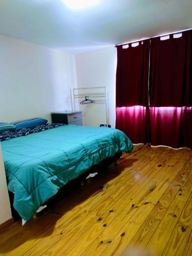 1 dormitorio con cama verde y cortinas rojas en Departamento 1 ambientes amueblado rafael calzada zona sur en Villa Calzada