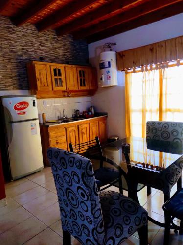cocina con mesa, sillas y nevera en Departamento 1 ambientes amueblado rafael calzada zona sur en Villa Calzada