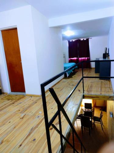 Habitación con escalera y habitación con mesa y sillas. en Departamento 1 ambientes amueblado rafael calzada zona sur en Villa Calzada