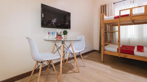 a room with a table and chairs and a bunk bed at RedDoorz Plus @ Cuarto Verde Staycation in Manila