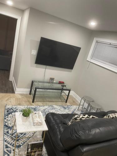 Uma televisão e/ou sistema de entretenimento em Stunning & cozy freshly renovated 2 bedroom basement unit