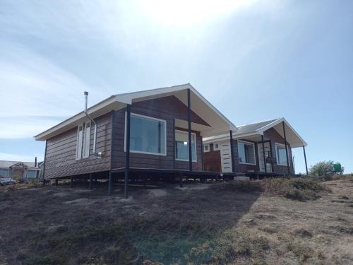 a house sitting on top of a field at Cabañas Altos de Leñadura in Punta Arenas