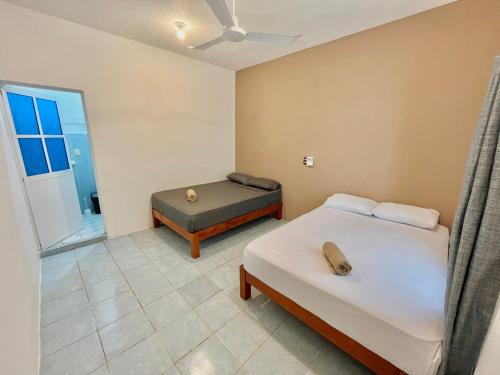 a bedroom with two beds and a window at Single Fin Suites & Rooms La punta zicatela in Brisas de Zicatela