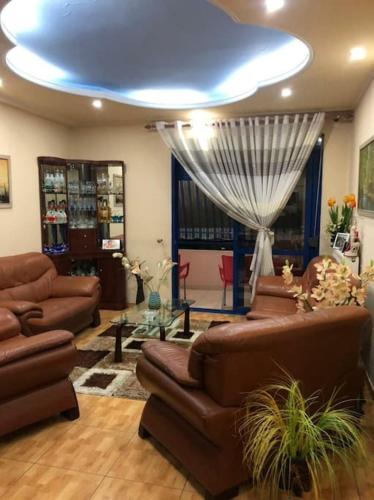a living room with leather furniture and a blue ceiling at Deluxe & Big Appartment City center in Fier