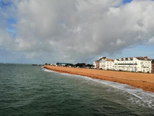 a beach with some buildings and the ocean and water at Angelica place in Portsmouth