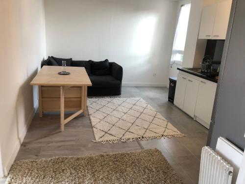 - un salon avec une table et un canapé noir dans l'établissement Evry Time, Évry-Courcouronnes