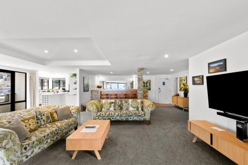 a living room with couches and a flat screen tv at The Glebe Apartments in Queenstown