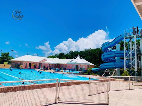 a large swimming pool with a water slide at SWILODGE VUE SUR MER ! Petit Déjeuner et Location de voiture possible in Le Moule