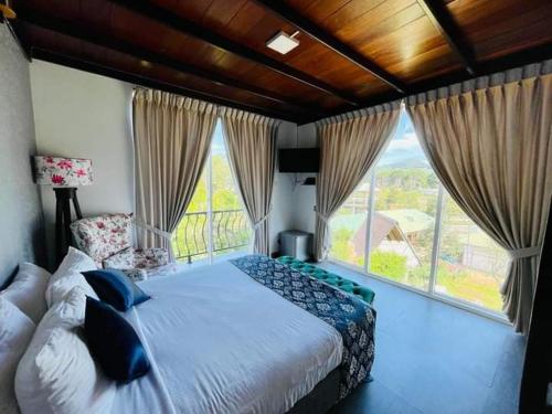 um quarto com uma cama grande e uma janela grande em THE EDGWARE em Nuwara Eliya