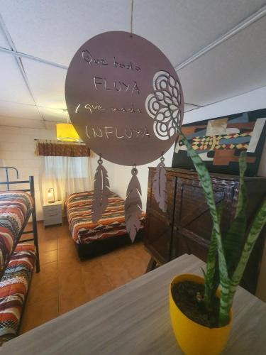 a room with a table with a plant and a sign at Hostel Morada Roots in Cordoba